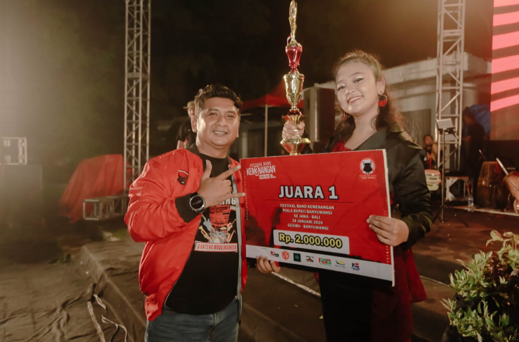 Ketua DPC BMI banyuwangi,Yusi saat memberikan hadiah kepada pemenang I Festival Band Kemenangan